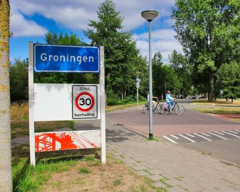 a blue sign sitting on the side of a road