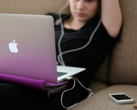 woman sitting on sofa with MacBook Air